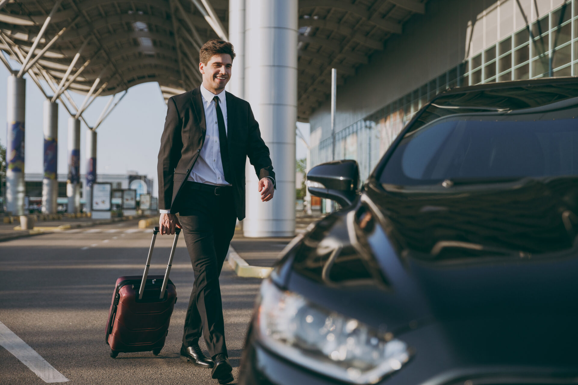 Man walking to chauffeur driven car at an airport